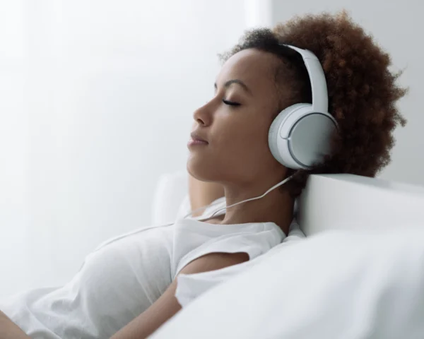 Femme muni d'un casque et qui fait une séance d'hypnose en ligne.