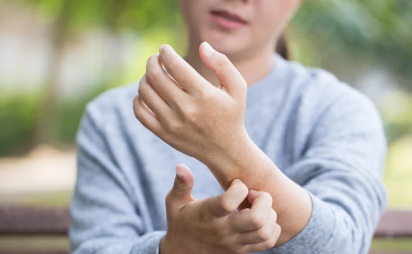 Personne grattant son avant-bras, illustrant comment l'hypnose peut aider à soulager les problèmes de peau comme l'eczéma ou le psoriasis.